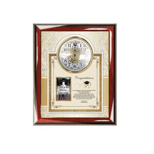 May include: A mahogany-colored wooden frame with a gold trim surrounds a white background with a gold clock face, a 2.5 inch by 4 inch photo opening, and a congratulatory message. The clock face has black Roman numerals and a gold center. The photo opening has a white border and the text "2.5W x 4H Photo Opening". The congratulatory message is in black text with a gold border and includes a graduation cap and a medical symbol.