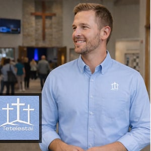 May include: A light blue button-down shirt with a white cross logo on the chest pocket. The image also includes a small square with a cross design and the word "Tetelestai".