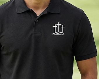 May include: Black polo shirt featuring a white graphic of three crosses and the word "Tetelestai" beneath. The shirt has a collared neckline and a three-button placket.