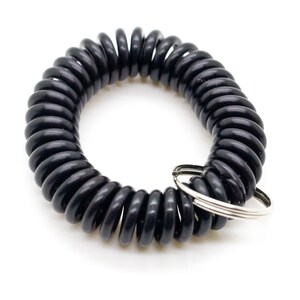 Può includere: Portachiavi retrattile nero con un anello in metallo argentato. Il portachiavi è fatto di una molla a spirale.
