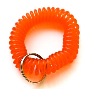 Può includere: Un portachiavi a spirale di colore arancione brillante con un anello di metallo argentato.