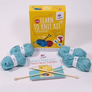 May include: A learn to knit kit for beginners, featuring four balls of light blue yarn, two wooden knitting needles, and instructions. The kit includes instructions for making a scarf, fingerless gloves, and a bunny.