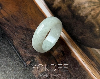 Peut inclure: Une bague en jade vert clair avec une surface lisse et polie. La bague est une bande pleine de forme arrondie. Le texte "YOKDEE JEWELLERY" est visible dans l'image.