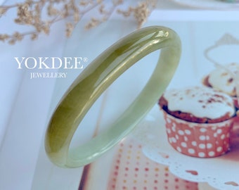 May include: A green jade bangle bracelet with a light green to dark green gradient. The bangle is smooth and polished.