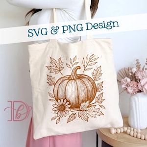 Pode incluir: Saco tote creme com uma ilustração castanha de uma abóbora, folhas e uma flor. As palavras "SVG & PNG Design" estão impressas na parte superior. O saco é segurado por uma pessoa que usa um top branco e uma saia rosa.