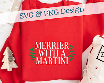 May include: A red sweatshirt featuring the text "Merrier With A Martini" in white, encircled by green leaves. The words "SVG & PNG Design" are across the top. Festive decorations are visible in the background. The sweatshirt is folded.