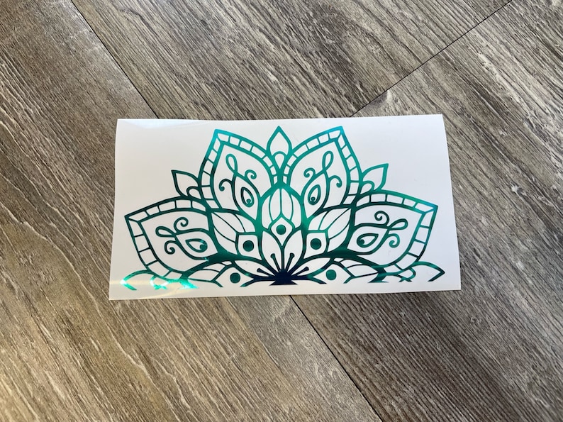 May include: A teal green mandala design with intricate details. The design is a half circle and has a gradient from dark teal to light teal.