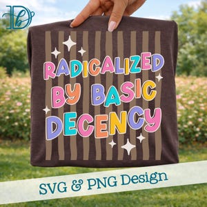 Op de afbeelding: Een bruin t-shirt met de tekst "RADICALIZED BY BASIC DECENCY" in kleurrijke letters. Het ontwerp bevat bruine verticale strepen en witte steraccenten. De onderkant van de afbeelding leest "SVG & PNG Design".