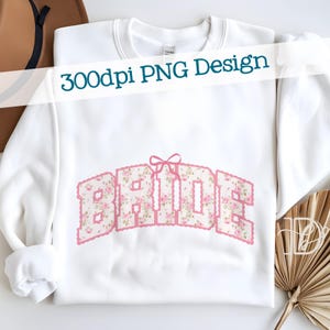 May include: White sweatshirt with the word "BRIDE" in a floral design. The letters are filled with a pink floral pattern and outlined in pink. A pink bow is above the word. The text "300dpi PNG Design" is across the top.