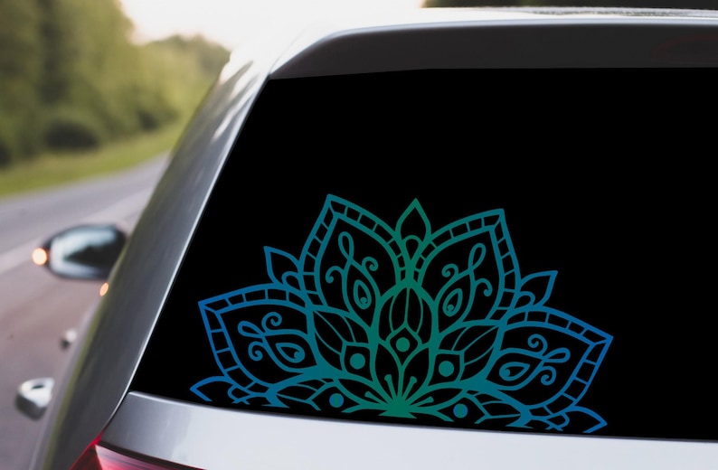 May include: A blue and green mandala design decal for a car window. The decal is a half circle and features intricate details.