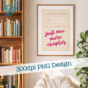May include: A framed print featuring a vintage library card design with the words "just one more chapter" in pink script. The print has a cream-colored background and a wooden frame. A bookshelf filled with books is visible in the background.