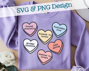 May include: A lilac-colored sweatshirt featuring several heart-shaped candies with phrases like "forced proximity" and "fake dating." The text "SVG & PNG Design" is displayed across the top. A white rose and a hat are visible in the background.