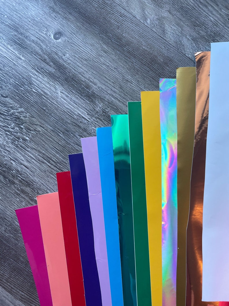 May include: A collection of 12 different colored vinyl sheets, including pink, red, purple, blue, green, yellow, gold, iridescent, and white.