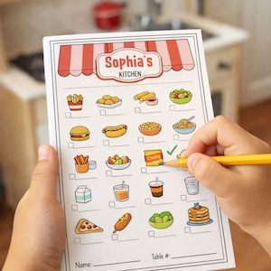 May include: A white notepad with a red and white awning design at the top, featuring the text "Sophia's Kitchen." The notepad has illustrations of various food items with check boxes. A pencil is marking a check box.