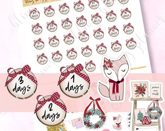May include: A set of Christmas countdown stickers featuring a fox, a wreath, a Christmas tree, and a small wooden shelf with a Christmas village scene. The stickers are decorated with red and white plaid bows and feature the words "peace on earth".