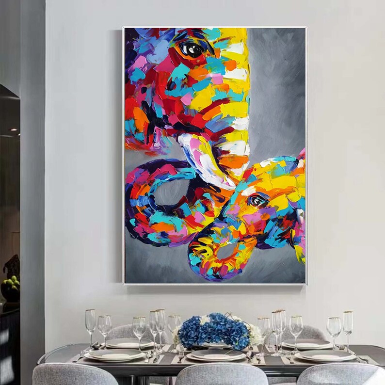 May include: A colourful abstract painting of two elephants, one large and one small, with a grey background. The elephants are painted in a variety of bright colours, including pink, yellow, blue, and green.