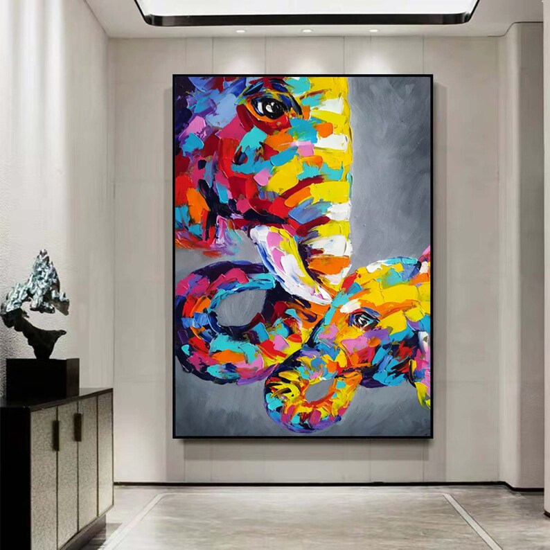 May include: A colourful abstract painting of two elephants, one large and one small, with their trunks intertwined. The painting is done in a bold, expressive style with bright colours and thick brushstrokes.