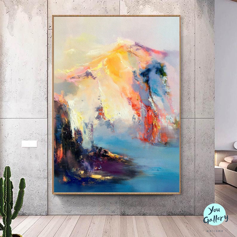 May include: Abstract painting of a mountain range with a blue, yellow, pink, and orange color scheme. The painting is framed in a wooden frame.