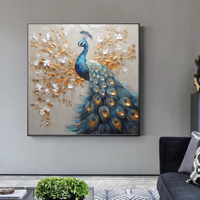K&ouml;nnte beinhalten: Ein Gem&auml;lde eines Pfaus mit blauen und gr&uuml;nen Federn und goldenen Akzenten. Der Pfau steht auf einem hellbraunen Hintergrund mit wei&szlig;en und goldenen Akzenten.