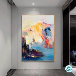 May include: Abstract painting with a colorful mountain scene in shades of blue, yellow, pink, and orange. The painting has a textured, brushstroke effect.