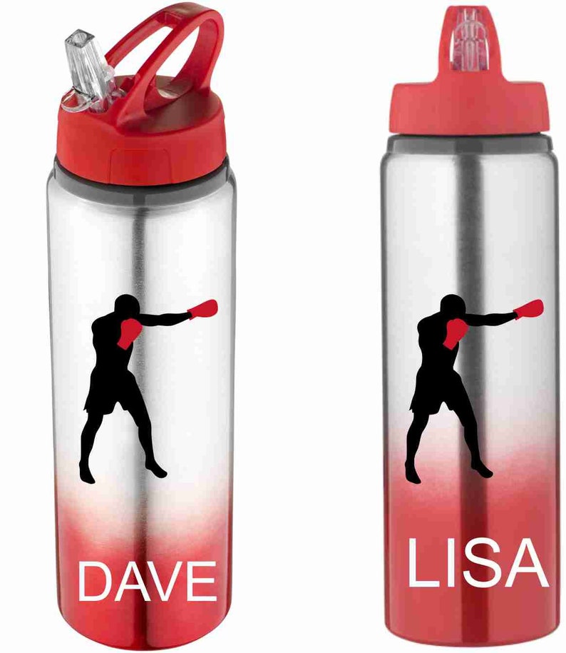 Puede incluir: Dos botellas de agua de acero inoxidable con tapas rojas y un degradado rojo en la parte inferior. Una botella tiene el nombre "DAVE" impreso en ella y la otra tiene el nombre "LISA" impreso en ella. Ambas botellas presentan una silueta de un boxeador con guantes de boxeo rojos.