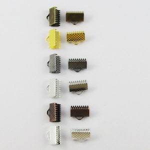 May include: Assortment of metal cord end stoppers in various finishes, including gold, silver, black, bronze, and copper. Each stopper has a small loop for attaching to a cord or string.