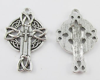 May include: Two silver Celtic cross charms. One charm features a detailed knotwork design, while the other has a more simple, textured design.