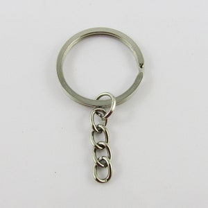May include: A silver key ring with a small chain attached. The key ring is circular and the chain is about 5 cm long.