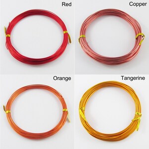 Op de afbeelding: Vier spoelen met gekleurde draad, elk gewikkeld in een cirkel. De kleuren zijn rood, koper, oranje en mandarijn.