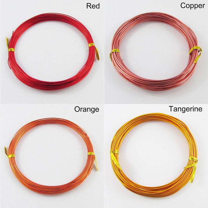 Op de afbeelding: Vier spoelen met gekleurde draad, elk gewikkeld in een cirkel. De kleuren zijn rood, koper, oranje en mandarijn.