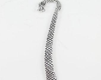 May include: Silver dragon bookmark with a curled tail and a detailed dragon head.