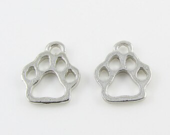 May include: Two silver metal paw print charms with a loop at the top for attaching to jewellery or other crafts.