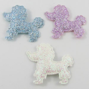 May include: Three glitter poodle shapes in blue, purple, and white. The poodles are made of felt and have a sparkly finish.