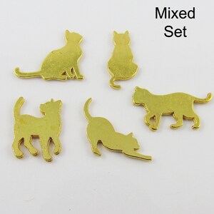 Puede incluir: Un conjunto de cinco dijes de metal dorado en forma de silueta de gato. Los dijes est&aacute;n en varias poses, incluyendo sentados, de pie y acostados. Los dijes son perfectos para agregar un toque de fantas&iacute;a a las joyas, las manualidades y otros proyectos.