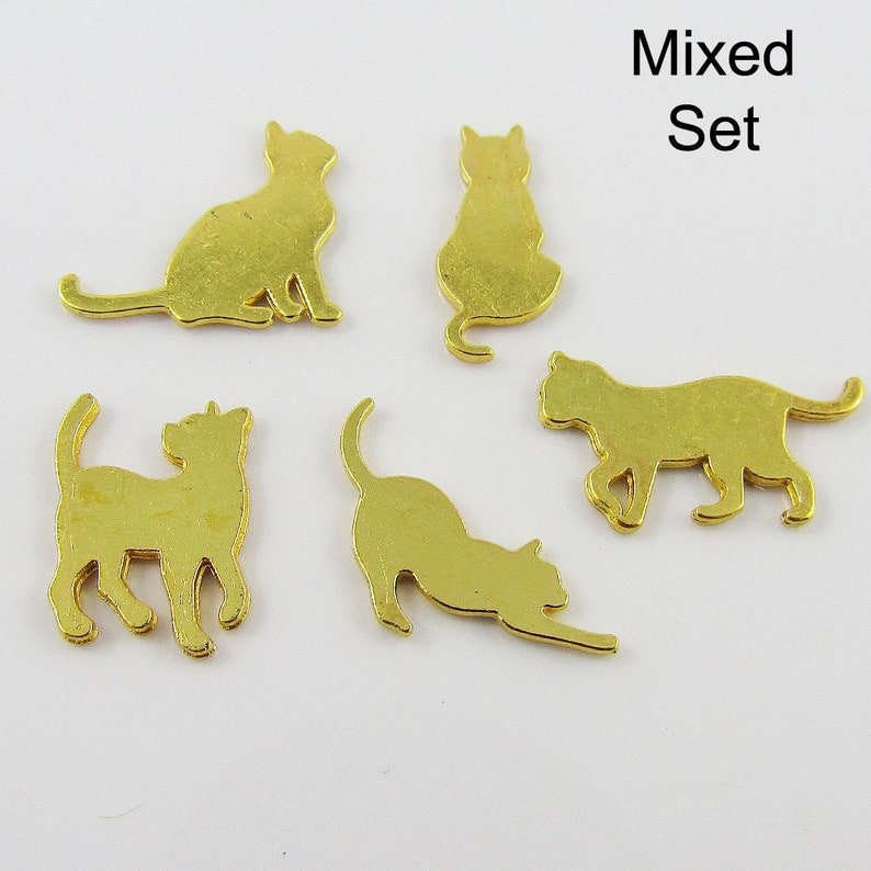 Puede incluir: Un conjunto de cinco dijes de metal dorado en forma de silueta de gato. Los dijes est&aacute;n en varias poses, incluyendo sentados, de pie y acostados. Los dijes son perfectos para agregar un toque de fantas&iacute;a a las joyas, las manualidades y otros proyectos.
