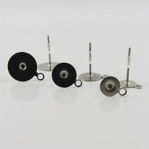 May include: Three silver earring posts with black round earring backs. Each back has a small hole in the centre and a loop on the side.