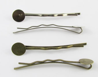 May include: Four hair clips with round metal embellishments. Two clips are silver and two are bronze.