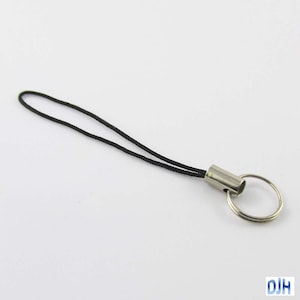 May include: A black string phone charm with a silver metal ring and a silver metal loop.