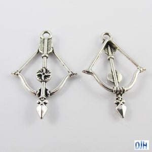 May include: Two silver-toned bow and arrow charms with a detailed design. The charms are ideal for jewellery making or crafting.