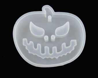 May include: White silicone mold shaped like a pumpkin with a scary face. The mold has a raised design of eyes, a nose, and a mouth.