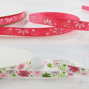 May include: Two rolls of pink and white ribbon with a floral pattern. The ribbon is 2.5 cm wide and has a satin finish.