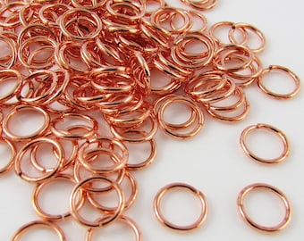 May include: A large pile of copper jump rings. The rings are small and round, and they are all the same size. They are perfect for jewelry making or other crafts.