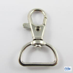 May include: Silver swivel trigger clasp with a D-ring. This metal clasp is commonly used for attaching keychains, lanyards, or other accessories.