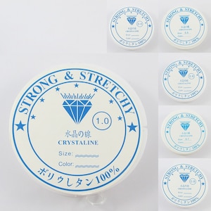 May include: A white spool of strong and stretchy elastic cord with a blue diamond logo and the text "Strong & Stretchy" and "Crystaline" printed on it. The spool is labelled with the size "1.0" and the text "Water-soluble" in Japanese.