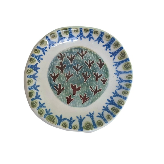 Wheel-thrown pottery with actual bird footprint impressions pressed into the clay — whimsical forest energy you won't find at any big-box store.