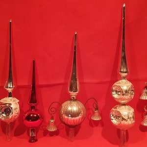 Peut inclure: Six d&eacute;corations de sommet d'arbre de No&euml;l en verre vintage. Trois sont argent&eacute;es avec un sommet pointu et une ampoule ronde au bas. Deux sont argent&eacute;es avec un sommet pointu et deux ampoules rondes au bas. Une est rouge avec un sommet pointu et une ampoule ronde au bas.
