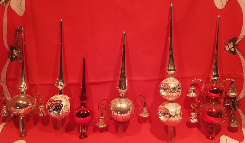 Peut inclure: Six d&eacute;corations de sommet d'arbre de No&euml;l en verre vintage. Trois sont argent&eacute;es avec un sommet pointu et une ampoule ronde au bas. Deux sont argent&eacute;es avec un sommet pointu et deux ampoules rondes au bas. Une est rouge avec un sommet pointu et une ampoule ronde au bas.