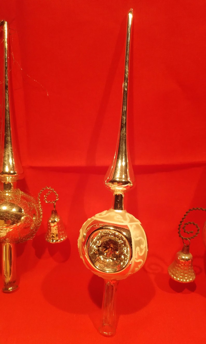 Peut inclure: Deux sommets d'arbre de No&euml;l vintage en verre argent&eacute; avec des cloches. Un sommet a un motif blanc givr&eacute; et l'autre a une surface textur&eacute;e.