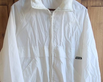 May include: White windbreaker jacket with a zipper closure and a fleece-lined collar. The jacket has a black logo that says "Pacific Trail".
