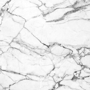 May include: White marble background with a natural veined pattern. The marble has a smooth, polished surface with a subtle sheen.